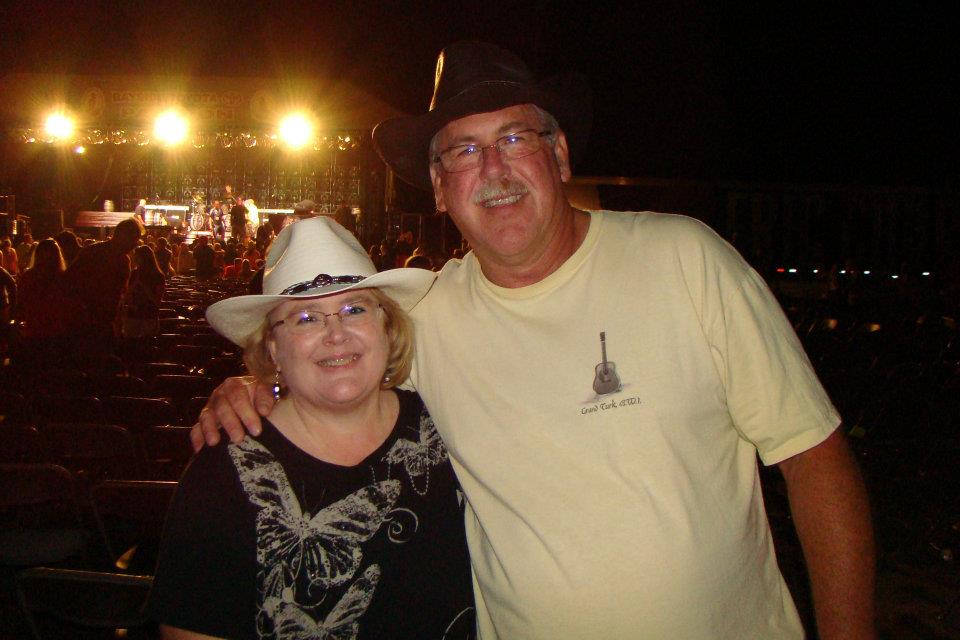 man and woman attend a country music concert wearing western hats