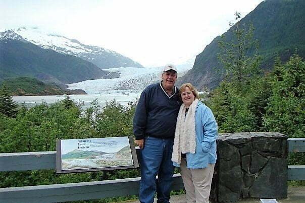 man and woman standing at an overlook in front of Mendenhall Glacier in Alaska