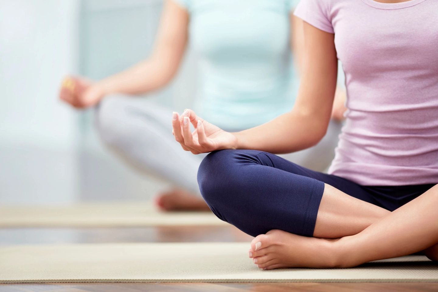 two women sitting on the floor in yoga poses