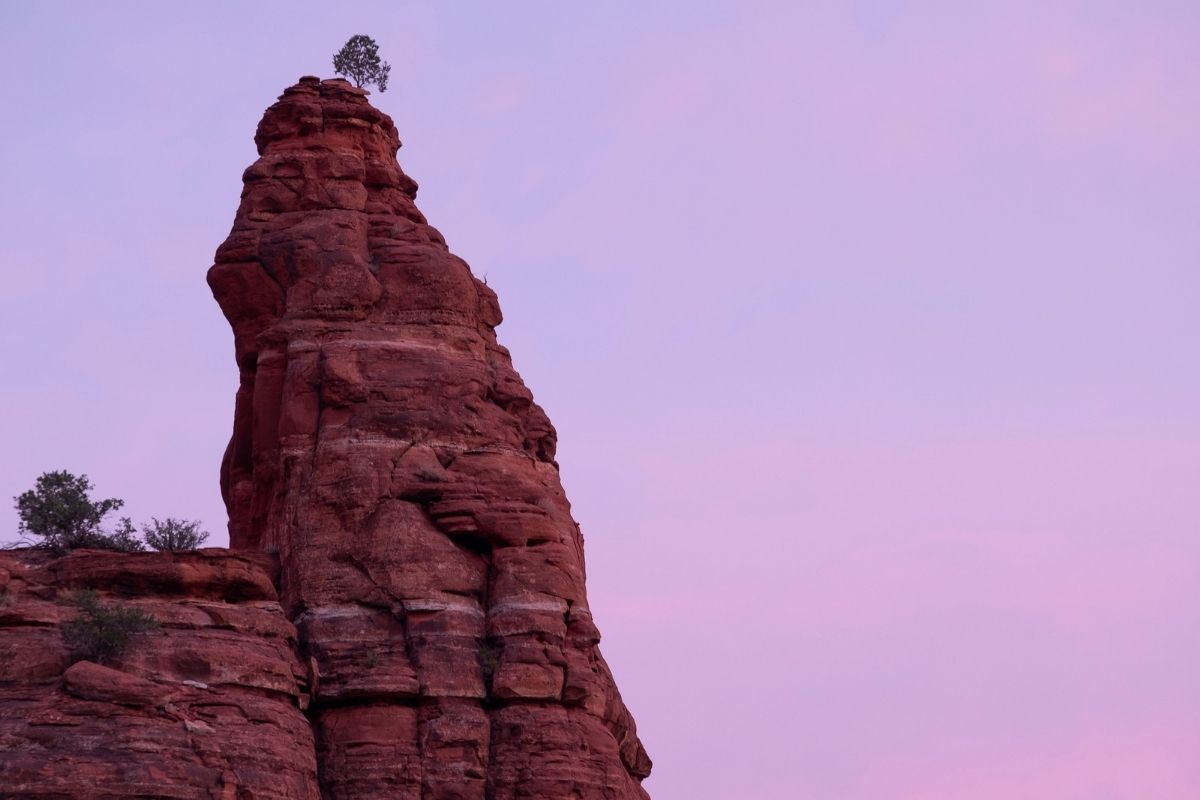 large red rocks with trees on top and sky in the background