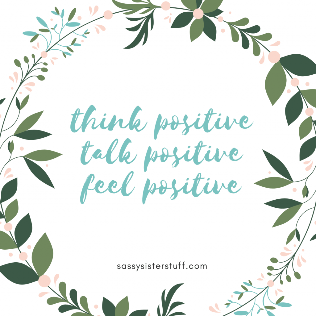 white background with a cirle of green leaves and a positivity quote inside the circle