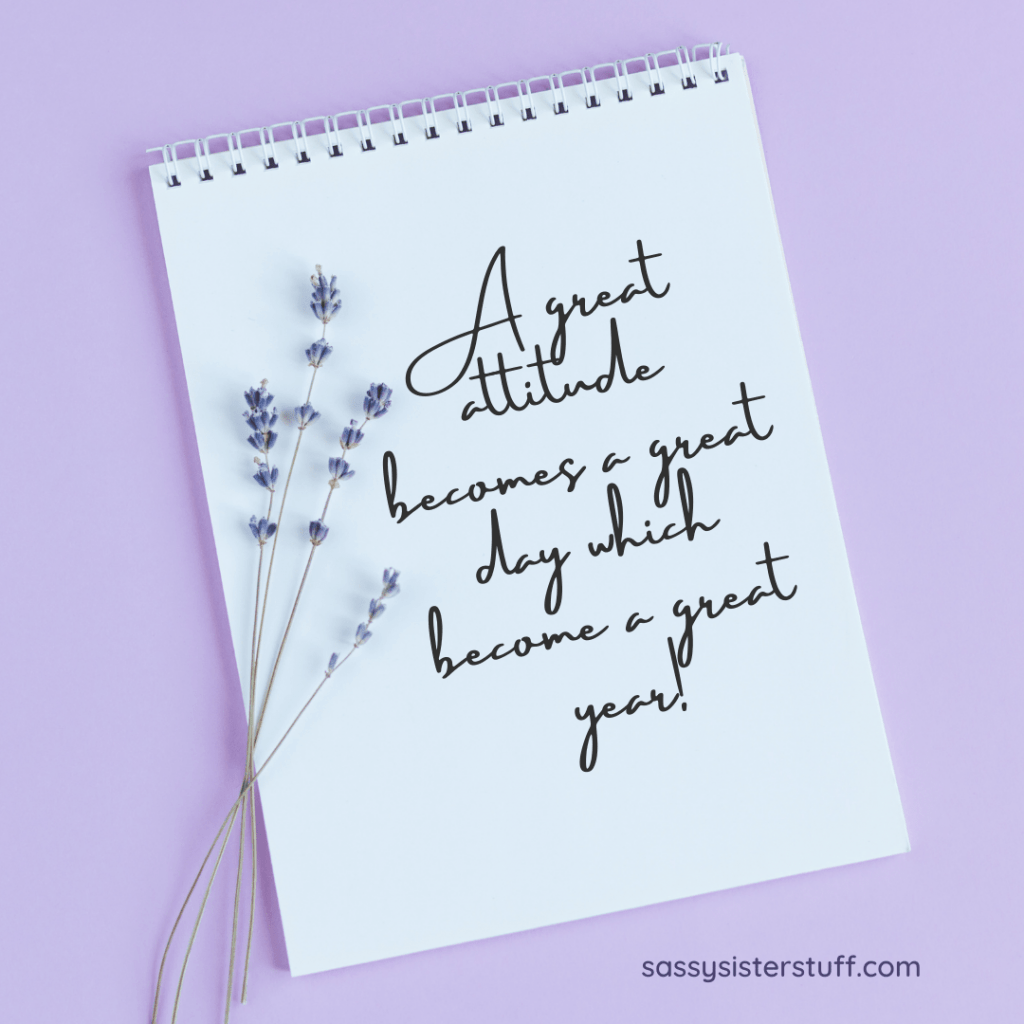 lavender background with a notebook and sprigs of lavender flowers plus a positivity quote on the notebook