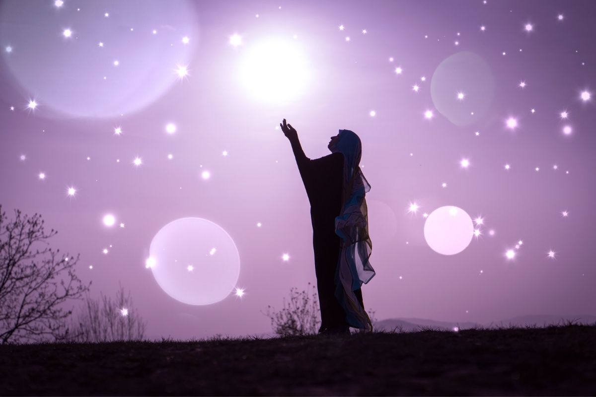 silouette of woman reaching into a skyline looking at the stars | lavender background
