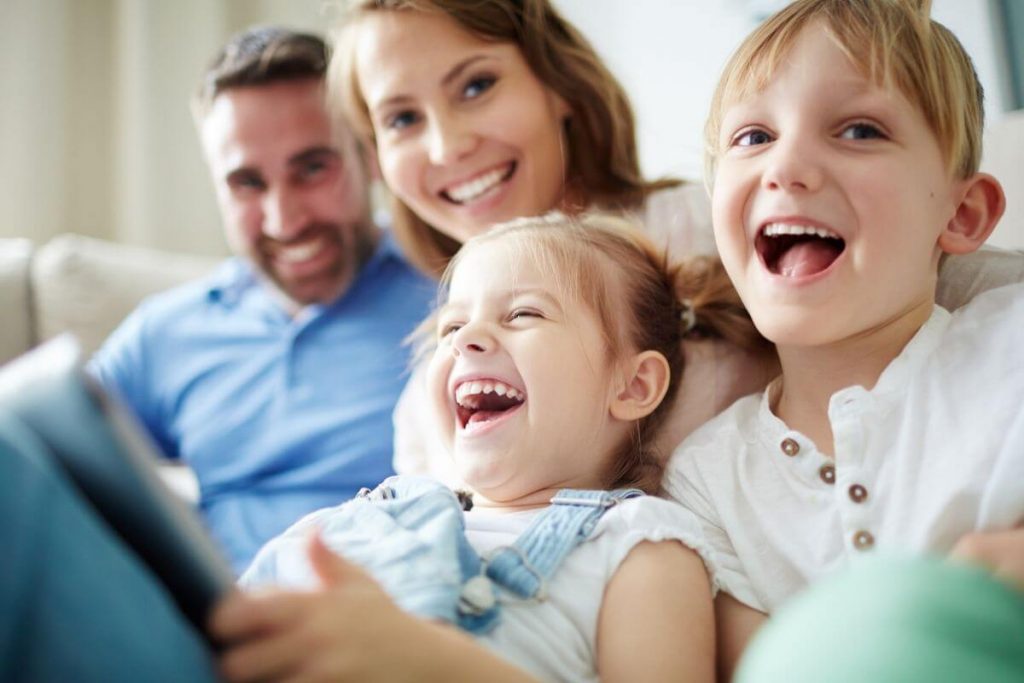 a happy family of four laughing together