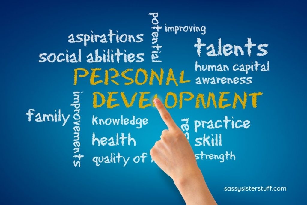 blue background with yellow words that say personal development and a hand pointing to the words with white traits of personal development written around the yellow words