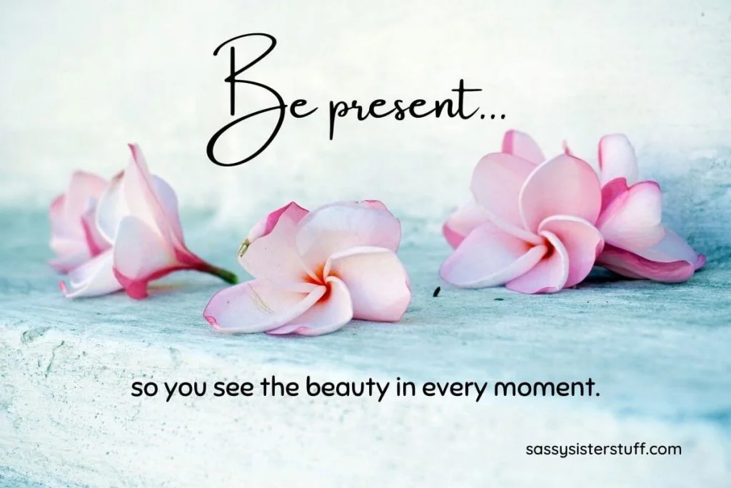 pink flowers on a light blue background with a quote about being mindful and present