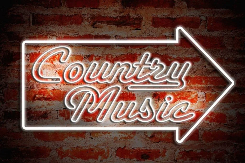 neon country music sign on a brick wall