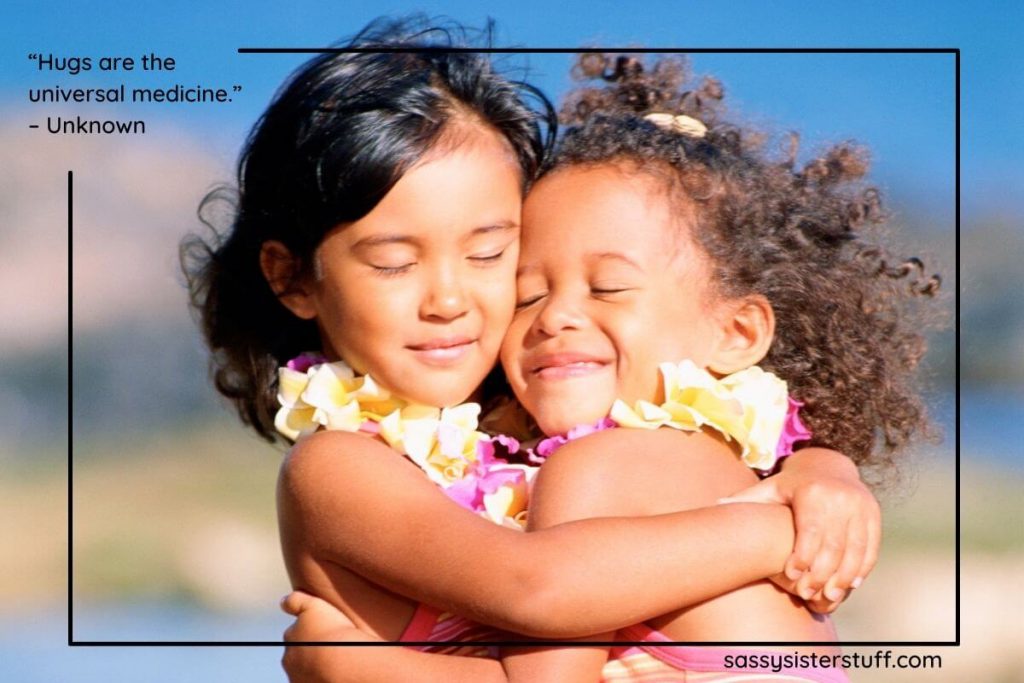 two little girls hugs with smiles on their faces