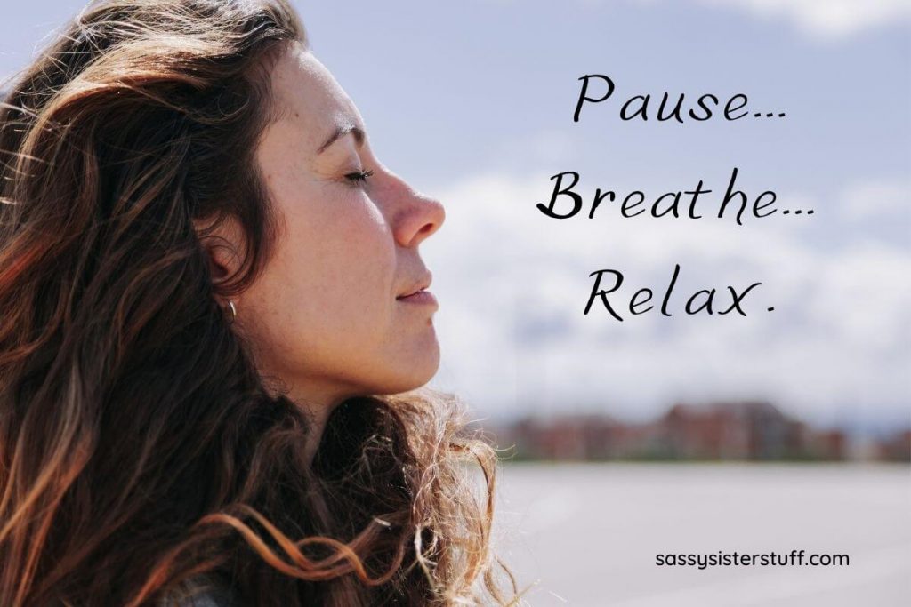 a dark haired woman breathes deeply and peacefully as she is finding her inner zen