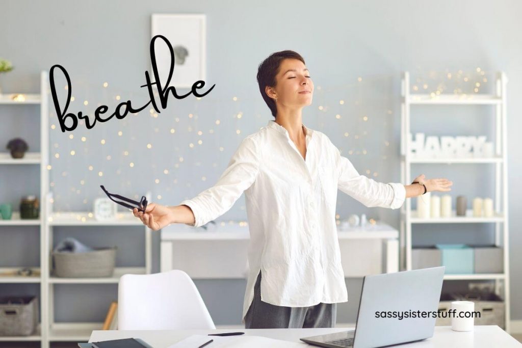 a woman in a home work space takes a break for a few deep breaths