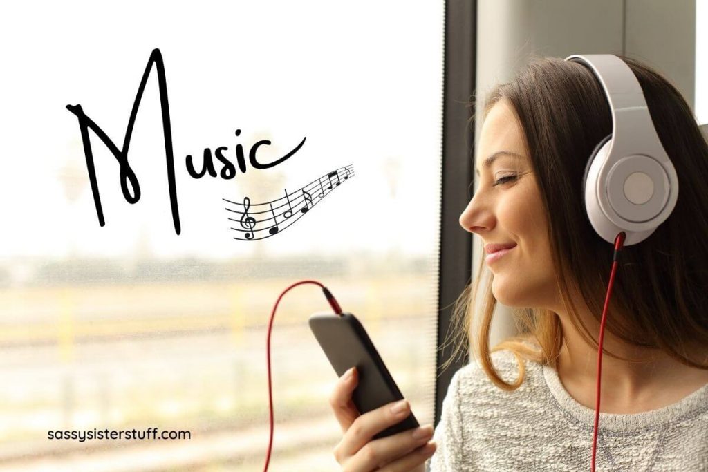 women listening to music on headphones as one of her acts of self care