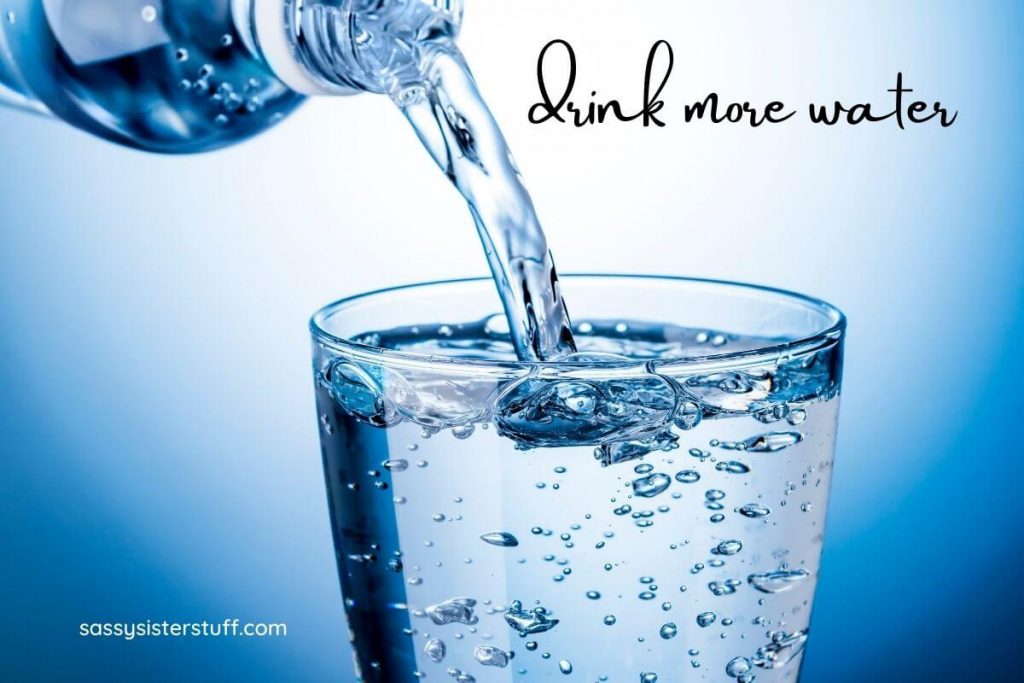 someone pouring water into a glass of water