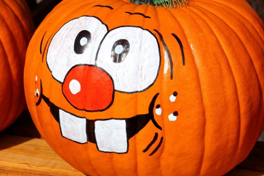 a pumpkin painted with a silly jack-o-lantern face for Halloween