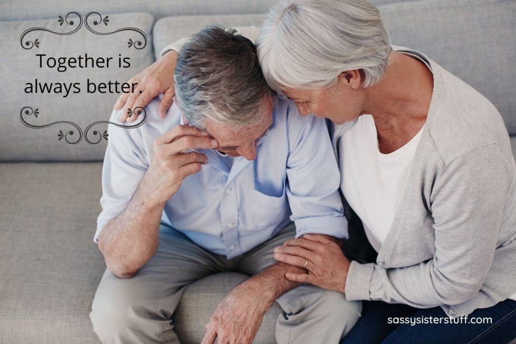 middle aged couple sitting together on a sofa together in deep thought as if feeling overwhelmed about something