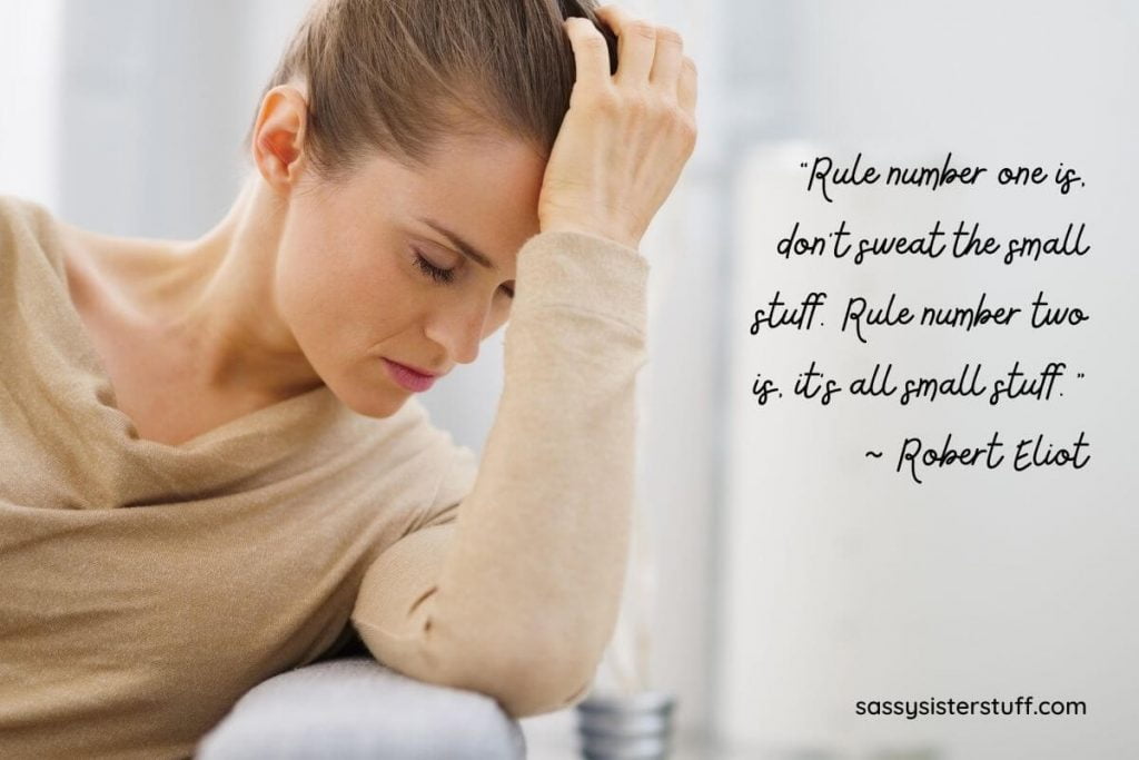 woman sitting with her head in her hand and eyes closed as if overwhelmed or stressed about something