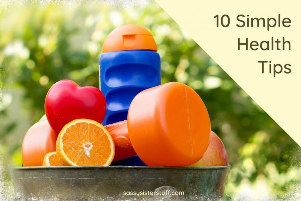 a bucket of health items including a water bottle an orange a weight an apple and a heart