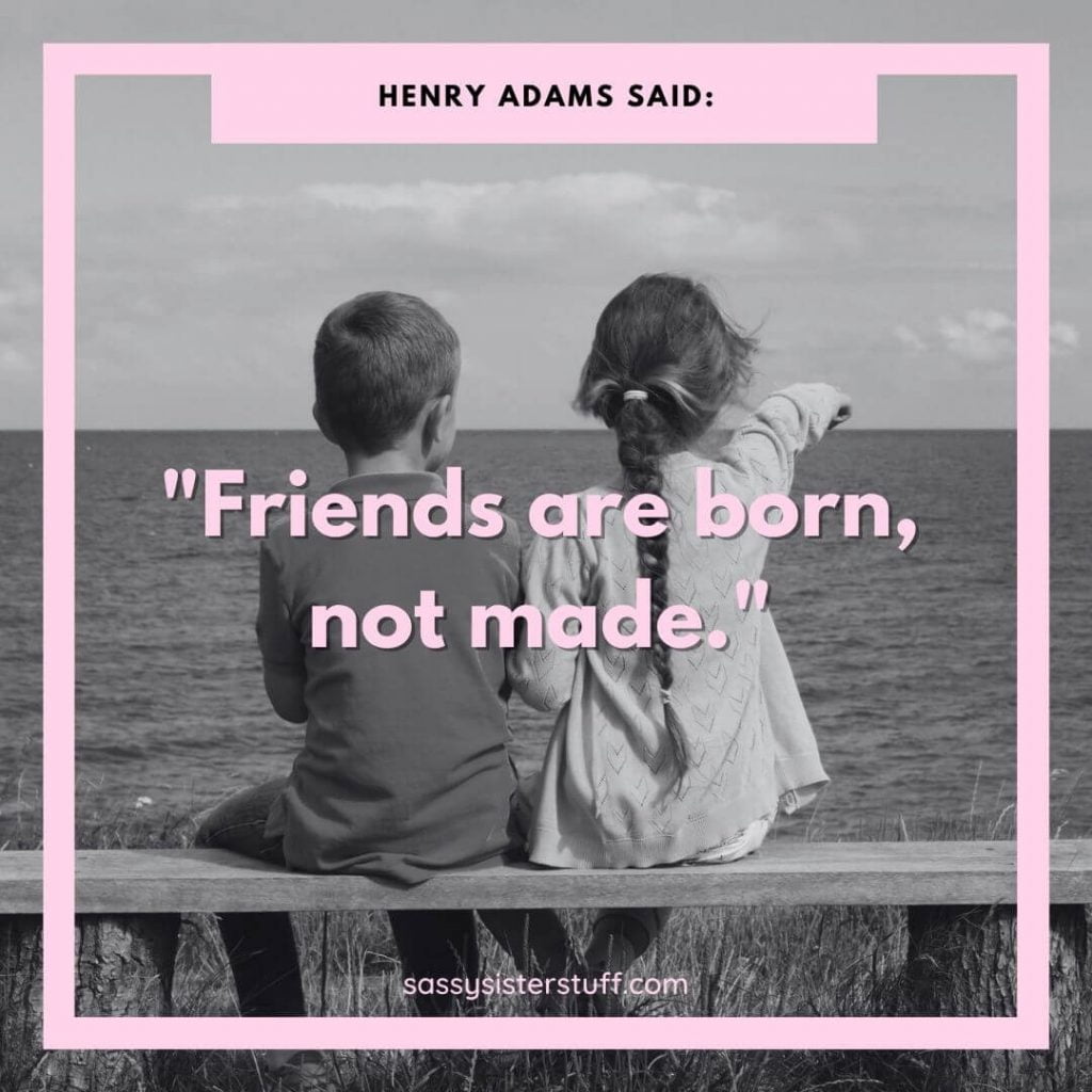 little boy and girl sitting on a wooden bench looking out over the water with a Henry Adams friendship quote