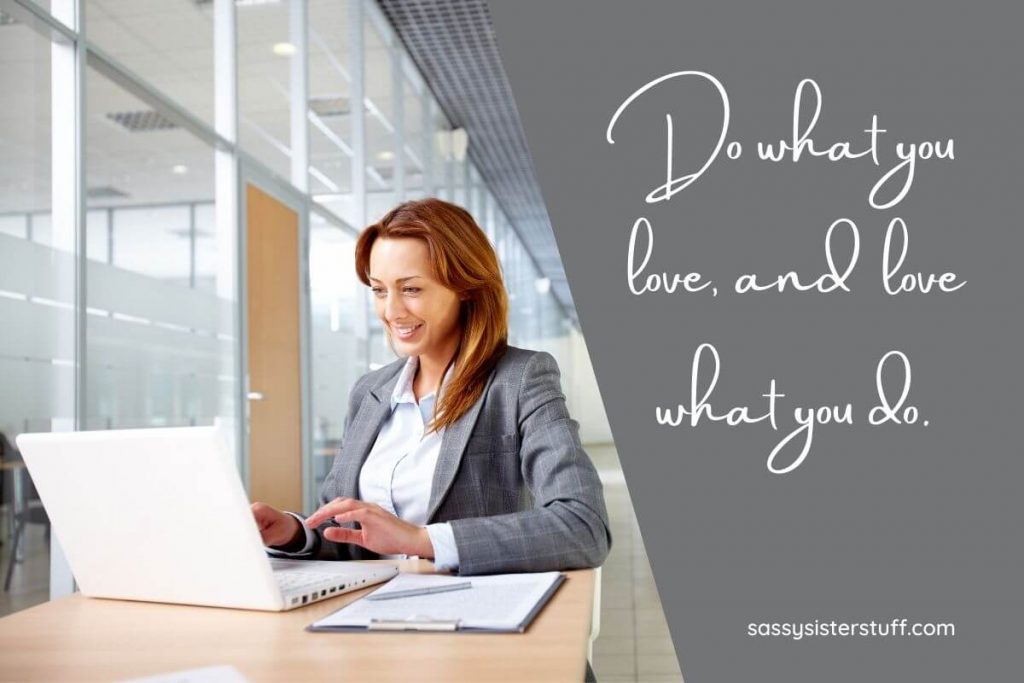 a happy woman sits at a desk with a laptop smiling because she understands the concept of occupational wellness