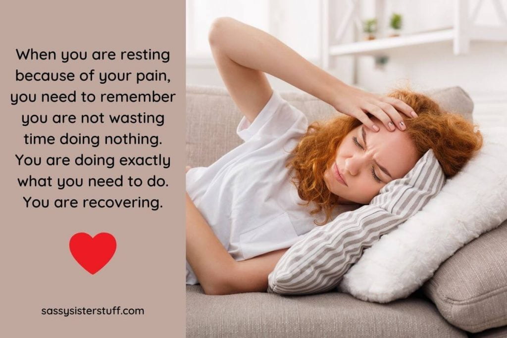 a woman lays on a sofa holding her head because she has a bad headache
