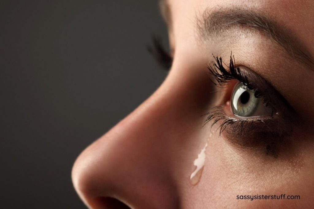 a close up image of a woman with a tear running down her cheek