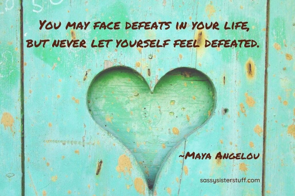 Maya Angelous quote about facing defeat in life with a green heart on a green background