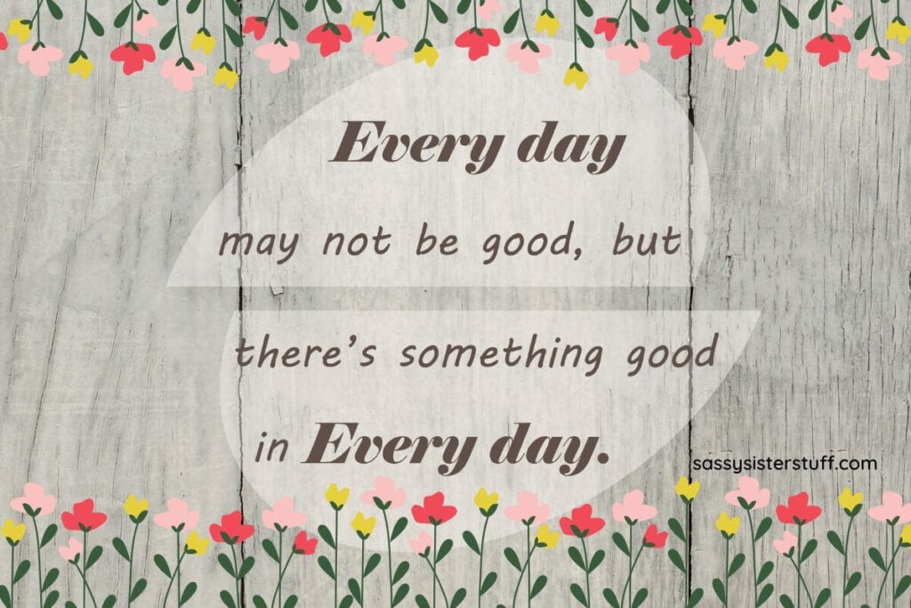 gray wooden background with whimsical flowers across the top and bottom and a stages of life quote that says every day may not be good but there's something good in every day