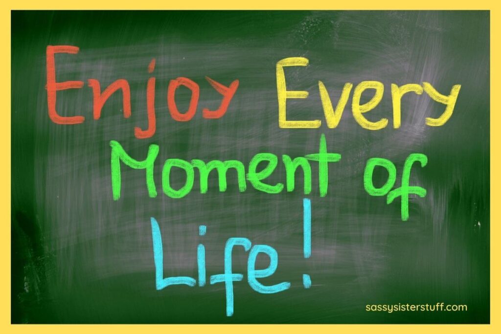 a green chalkboard with a yellow border and brightly colored words that say enjoy every moment of life
