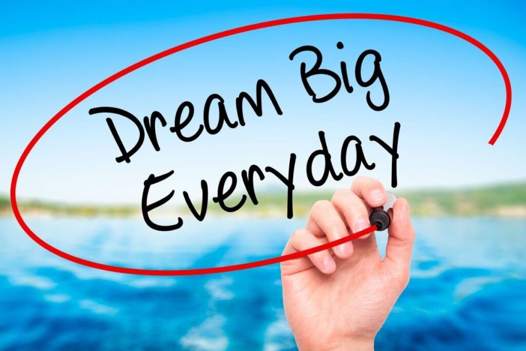 blue sky green grass blue lake and someone writing dream big everyday on the image