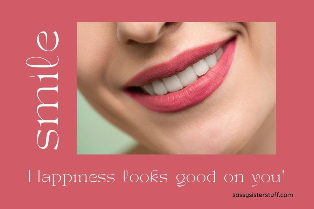 a pale red background with a close up photo of a womans beautiful smile and the words smile happiness looks good on you