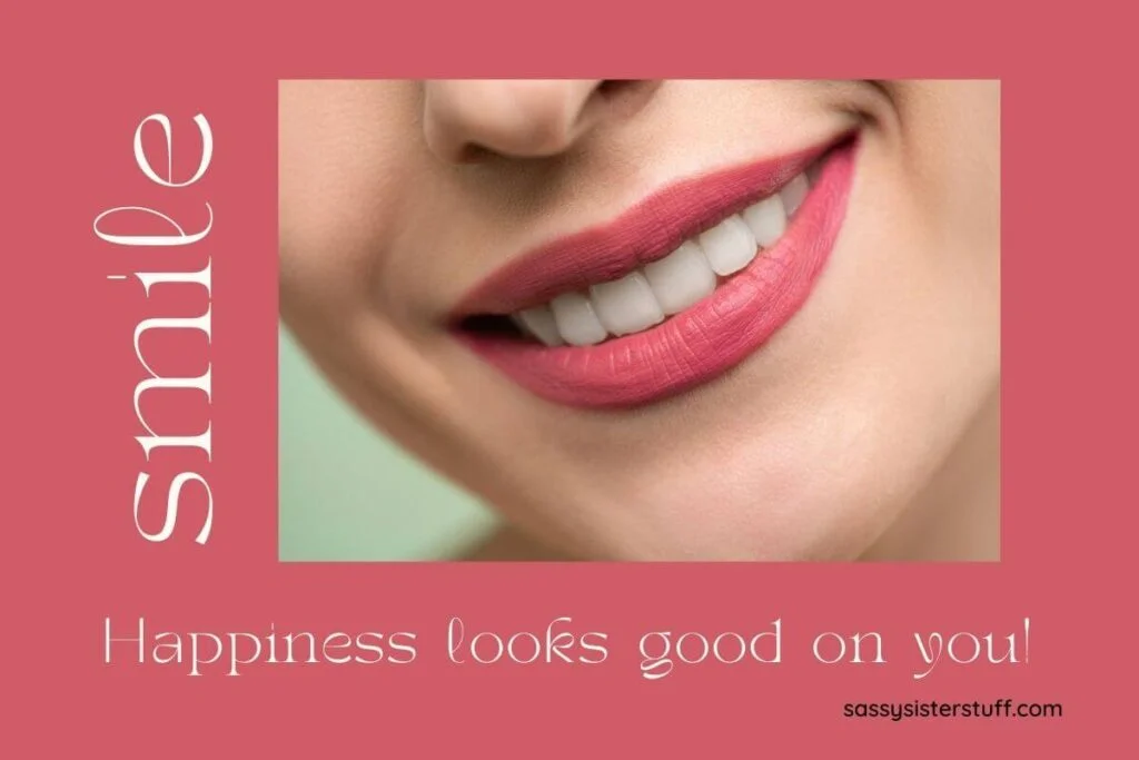 a pale red background with a close up photo of a womans beautiful smile and the words smile happiness looks good on you