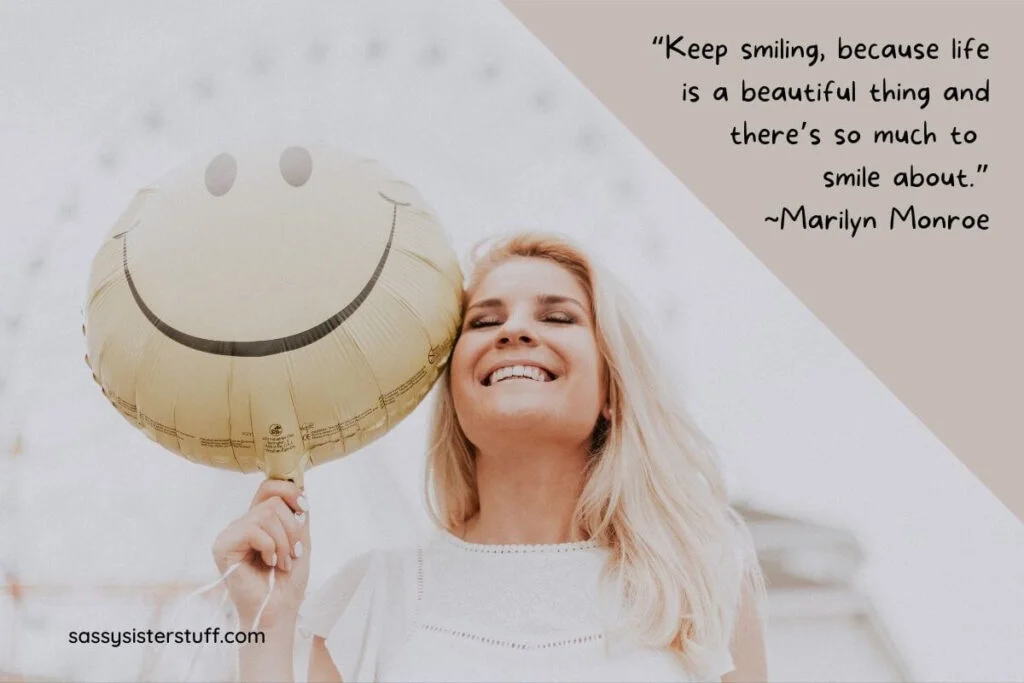 a beautiful blonde woman holding a pale yellow happy face balloon and a marilyn monroe quote about keep smiling