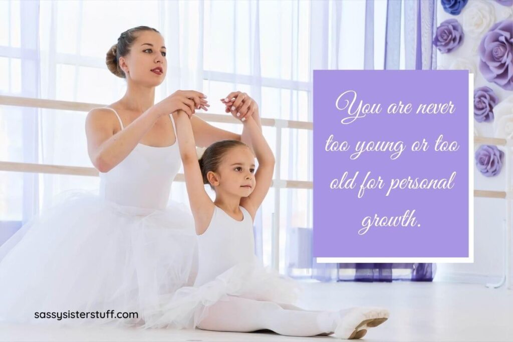a young woman ballet teacher dressed in a white ballet outfit teaches a little girl dressed in a matching costume to do ballet and pretty lavender flowers are on the wall next to them with a quote that says you are never too you or too old for personal growth