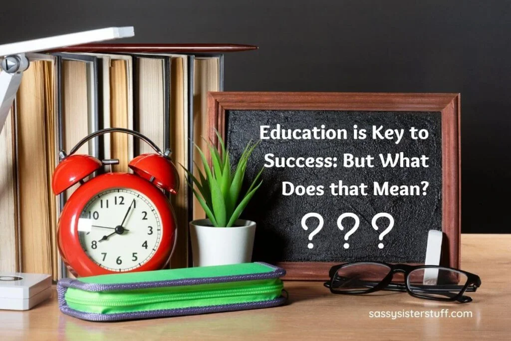 books clock green plant zippered notebook glasses and a framed chalkboard that says education is key to success all sit on a wooden shelf