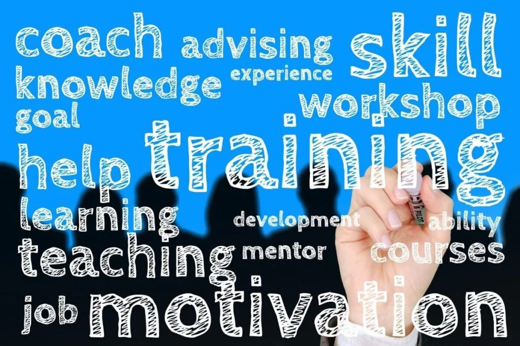an image with black silhouettes of heads against a blue background with a hand writing words that are associated with education is key to success