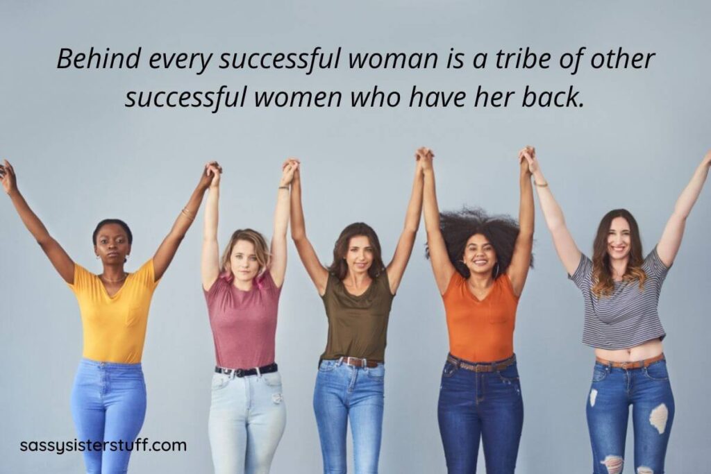 five women hold hands up in the air and smile at the camera confidently with a boss babe quotes over their heads