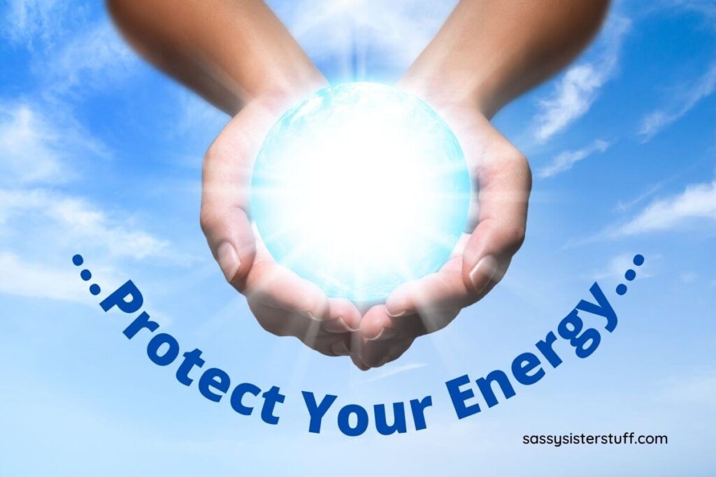 hands cups hodling a glowing sphere that seems to project energy against a blue sky background and the words protect your energy