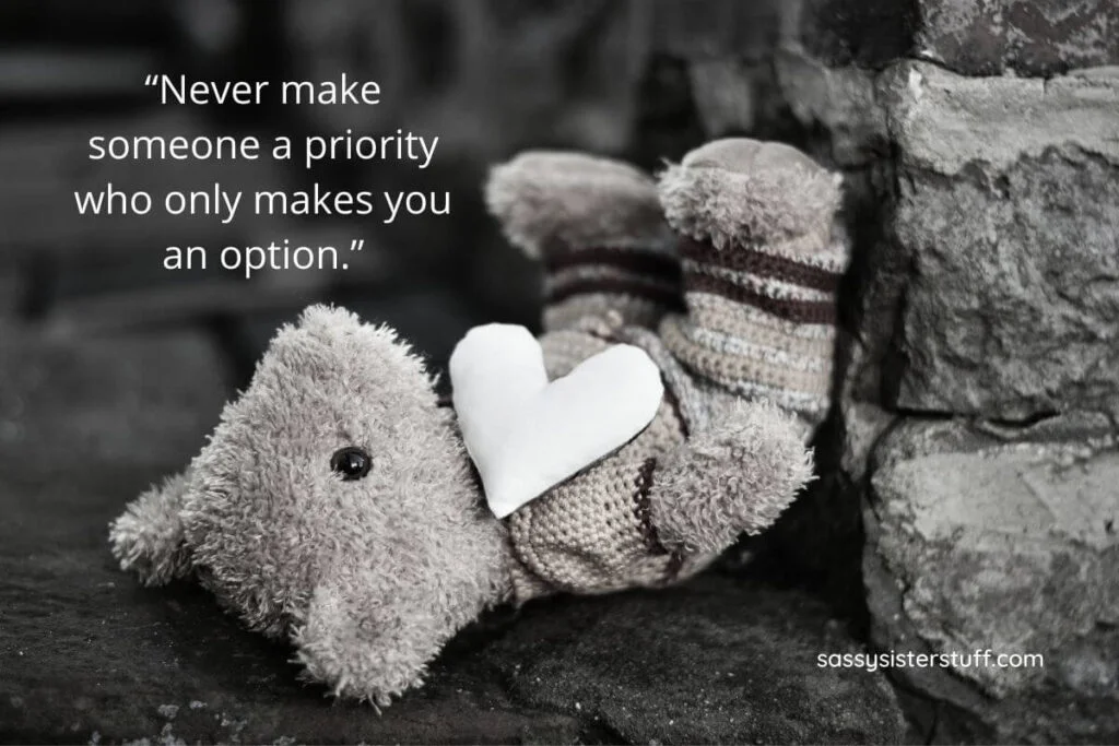 a black and white photo of a teddy bear laying against rocks and a quote that says never make someone a priority who only makes you an option