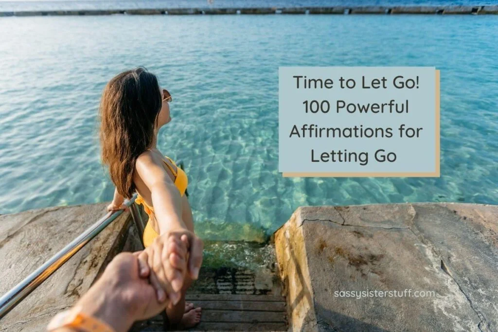 a middle aged woman in a yellow bathing suit reaches back and holds on to a man's hand as she goes down steps into a body of clear water in an symbolic motion showing time to let go 100 powerful affirmations for letting go