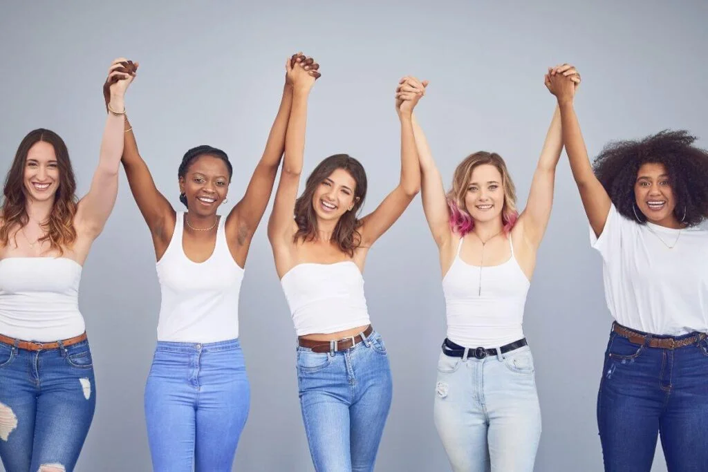 personal development presentation topics five ladies of varying shapes sizes and colors stand together in unity holding hands in the air smiling as they reaffirm key personal development topics that they focus on to help make their lives great