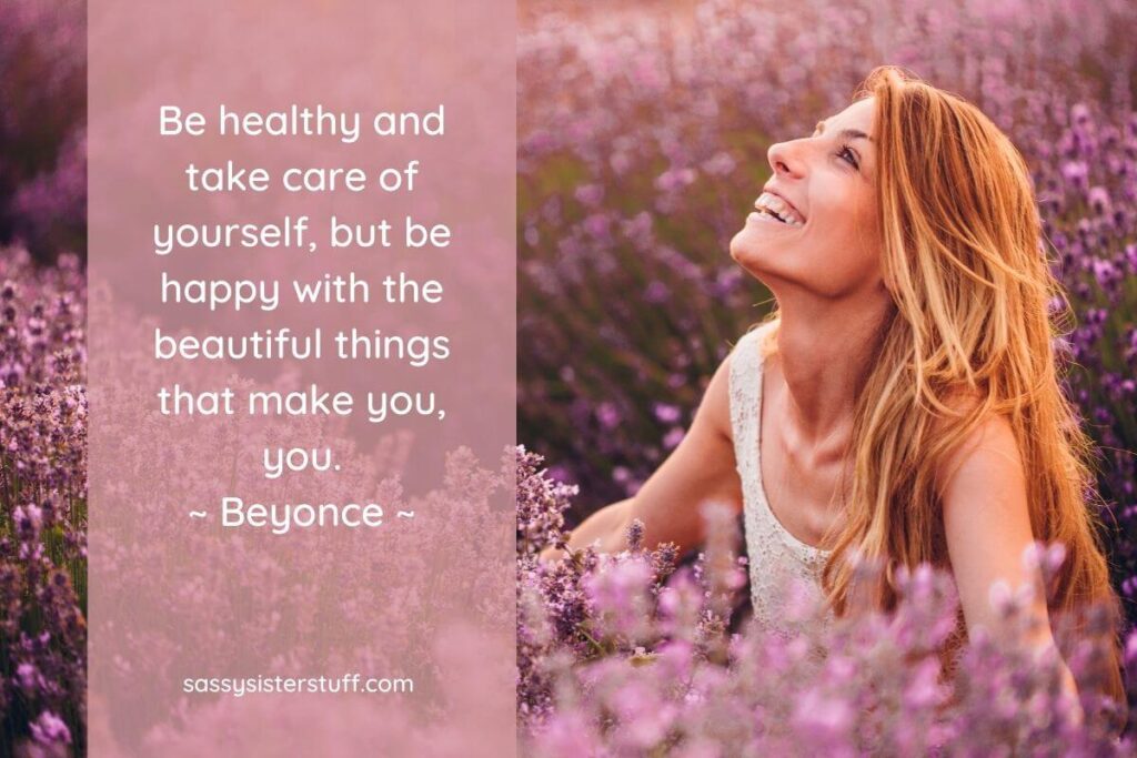 a beautiful young woman with long red hair sits in a of pink flowers and a choose happiness quote from beyonce