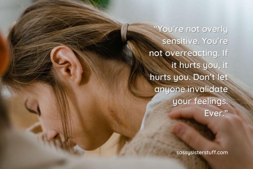 a young woman leans her forehead on her arm against a window and looks down in reflection as she ponders how to respond when someone says you're too sensitive plus an encouraging quote overlays the photo