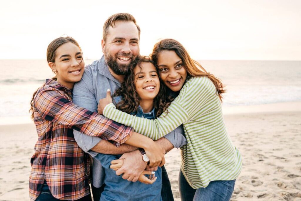 mom dad and two teen daughters enjoy the beach together after reciting affirmations for family