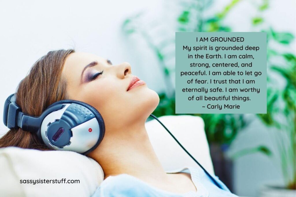 a relaxed woman listens to music on her headphones after reciting her grounding affirmations plus a grounding quote