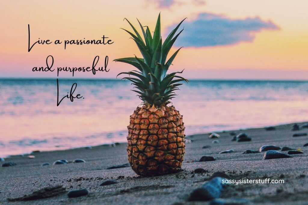 a pineapple sitting on a beach against a beautiful sunset