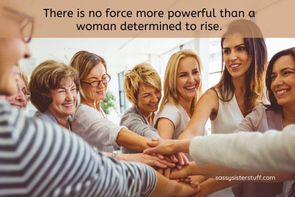 eight hard working women women gather together to do a hand stacking gesture in celebration of a job well done