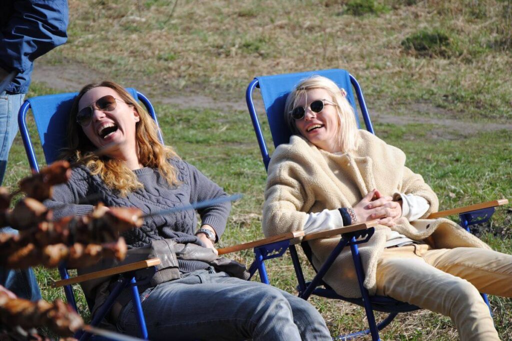 two woman relax outside in lawn chairs after self care reminders about getting fresh air