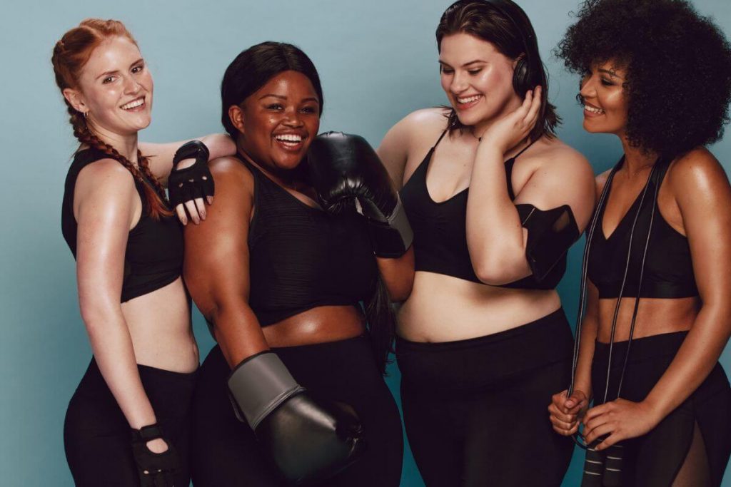 four women laugh and enjoy working out together after sharing body neutrality affirmations for confidence