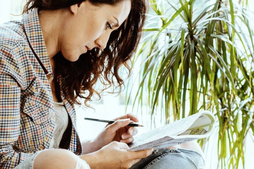 a women sits yoga style and writes in her journal for emotional self care