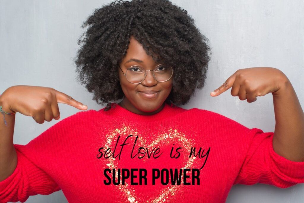 beautiful black woman wears a red shirt that says self love is my super power to advocate for the self love movement
