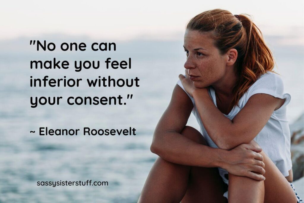 a young woman sits on a boulder on the shoreline contemplating feelings of insecurity, plus an inspirational quote from Eleanor Roosevelt